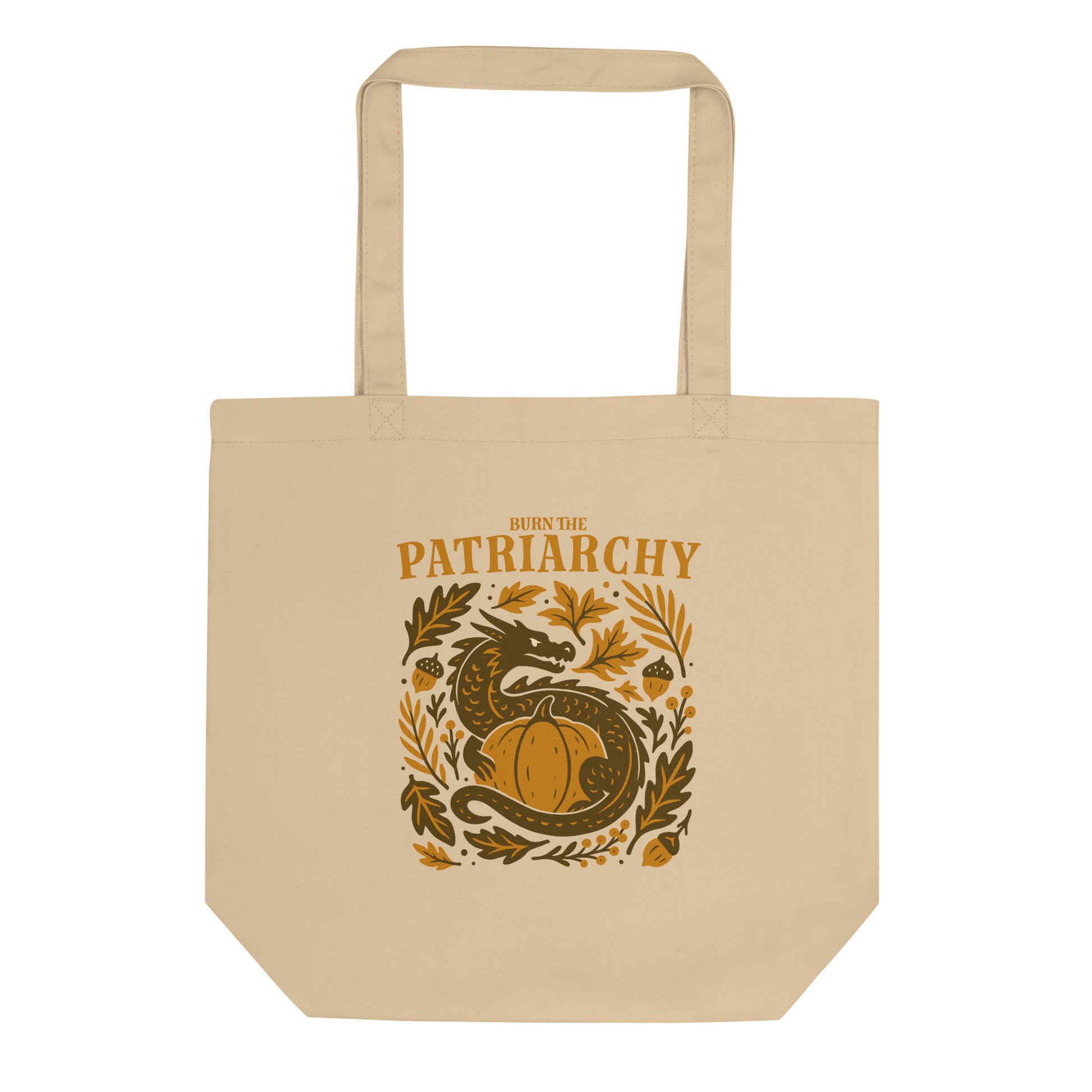 Beige eco tote bag with “Burn the Patriarchy” dragon and pumpkin design, feminist Thanksgiving print with acorns and leaves.