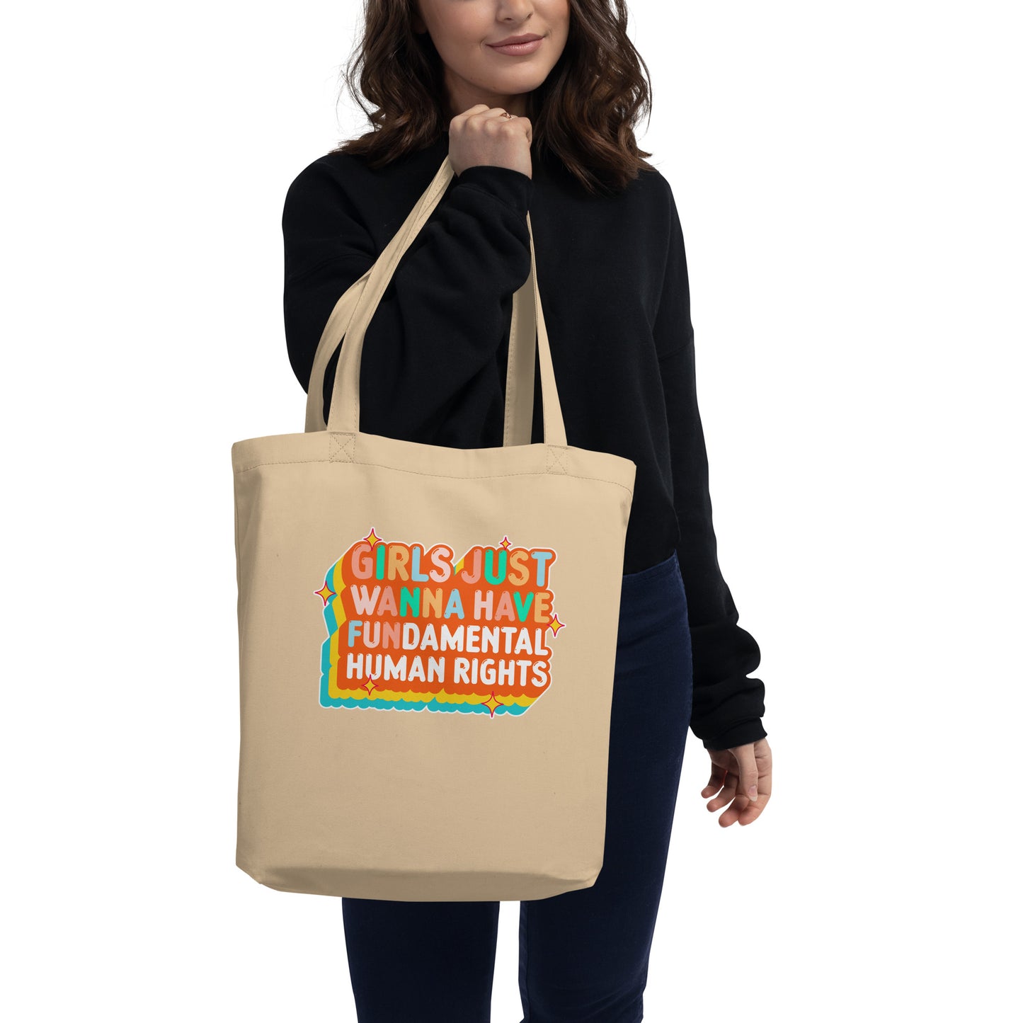 Model carrying the natural “Girls Just Wanna Have Fundamental Human Rights” eco tote with vibrant orange and teal typography. Sustainable feminist tote by Blue Wave USA.