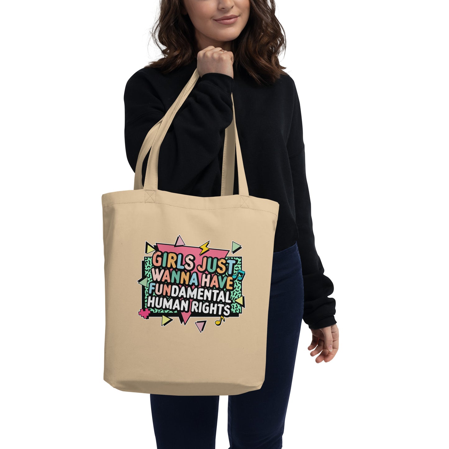 Model wearing the natural “Girls Just Wanna Have Fundamental Human Rights” tote on shoulder, featuring colorful retro art. Feminist empowerment tote by Blue Wave USA.
