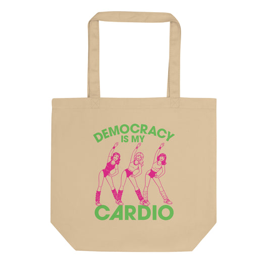 Eco tote bag featuring retro pink aerobics dancers with green “Democracy Is My Cardio” text, vintage fitness-inspired political humor artwork for progressive everyday accessories.