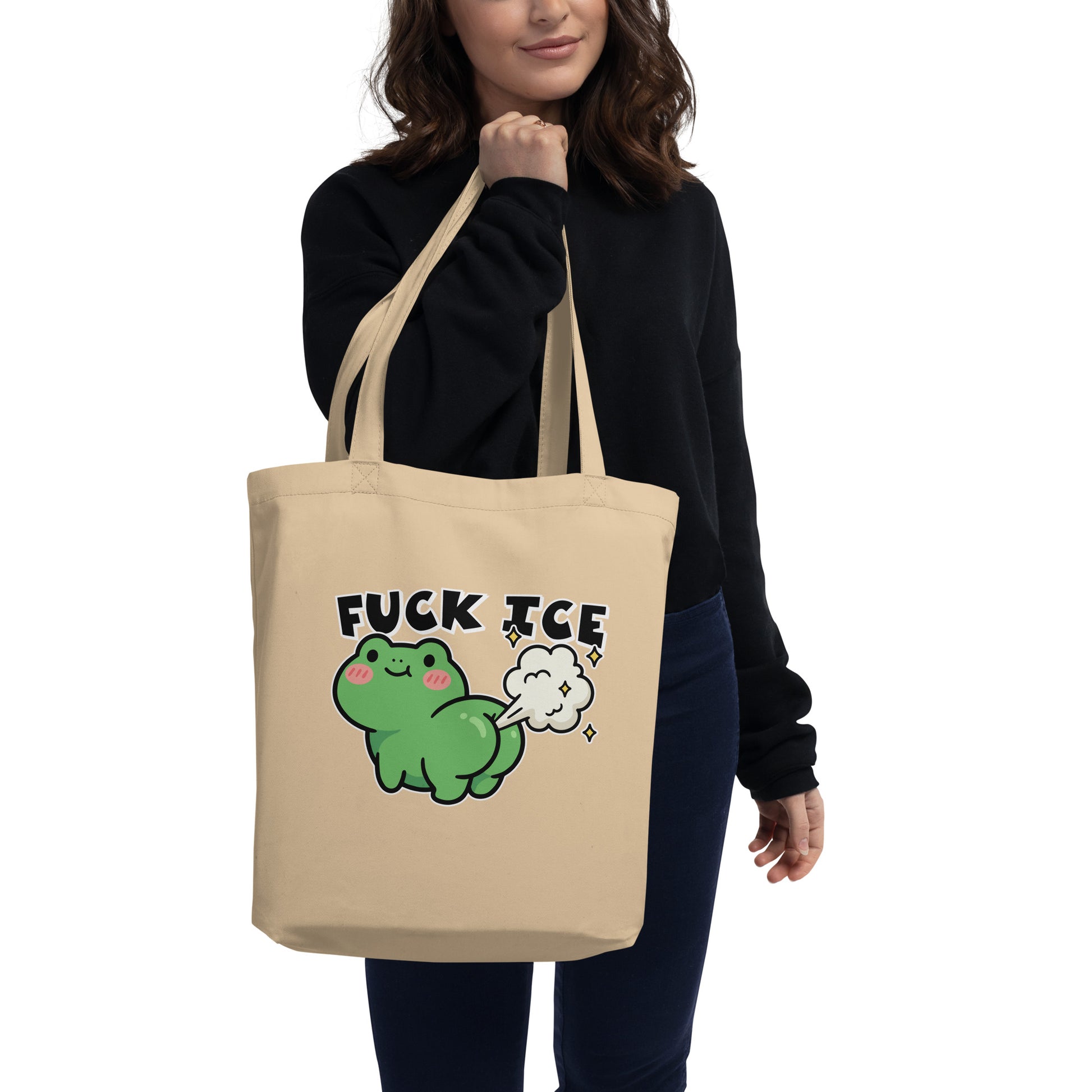 Model carrying natural canvas eco tote featuring cartoon frog with gas cloud and “Fuck ICE” phrase in playful activist style.
