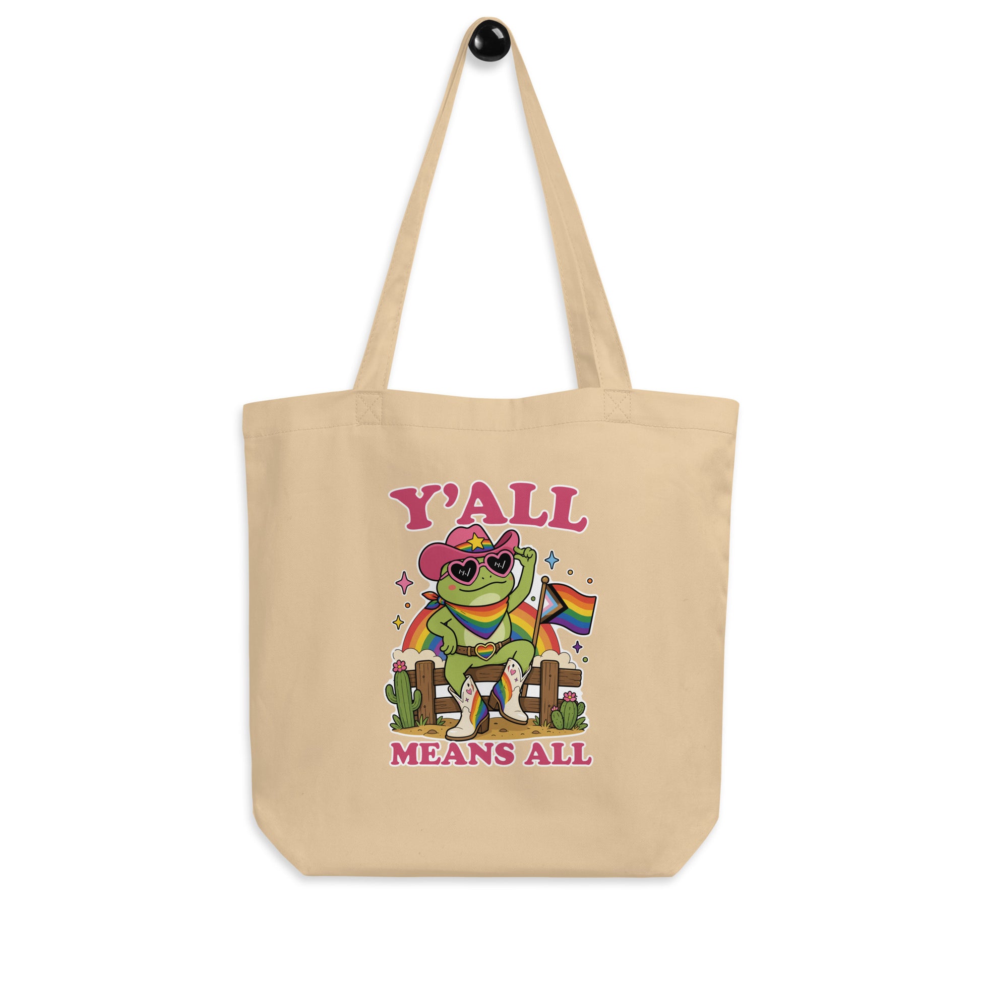 Natural cotton eco tote bag featuring colorful cowboy frog artwork, rainbow pride flag details, and inclusive “Y’All Means All” LGBTQ+ pride slogan.