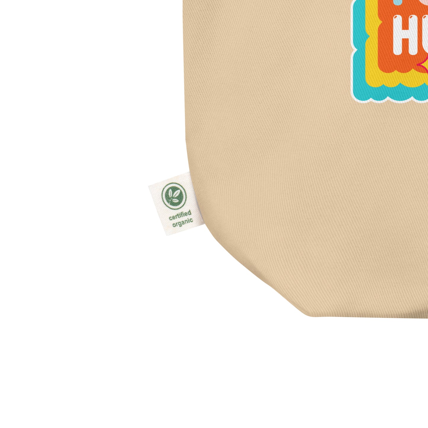 Close-up of organic cotton eco tote showing certified eco label and partial view of the colorful activist graphic. Durable, planet-friendly tote by Blue Wave USA.