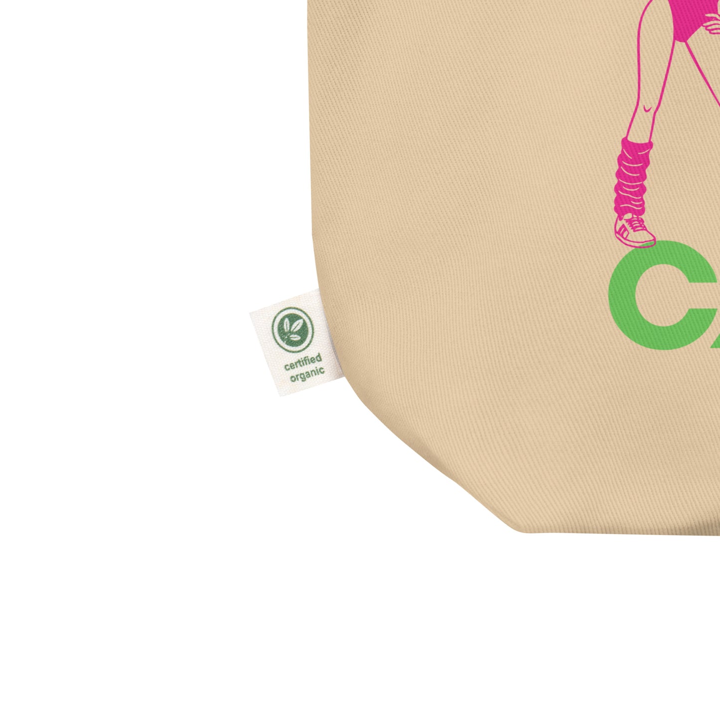 Close-up eco tote corner detail showing natural canvas texture and partial retro aerobics artwork with green cardio lettering from the democracy design.