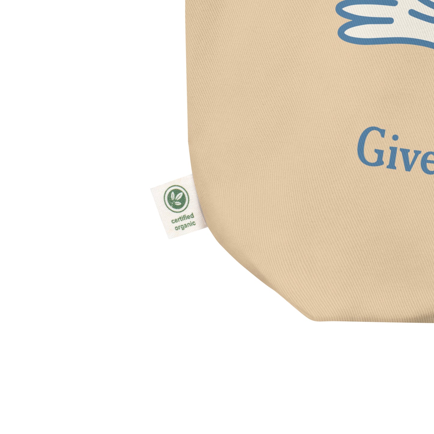 Close-up eco tote corner showing natural canvas texture with partial blue dove illustration and visible “Give Peace a Future” text detail.