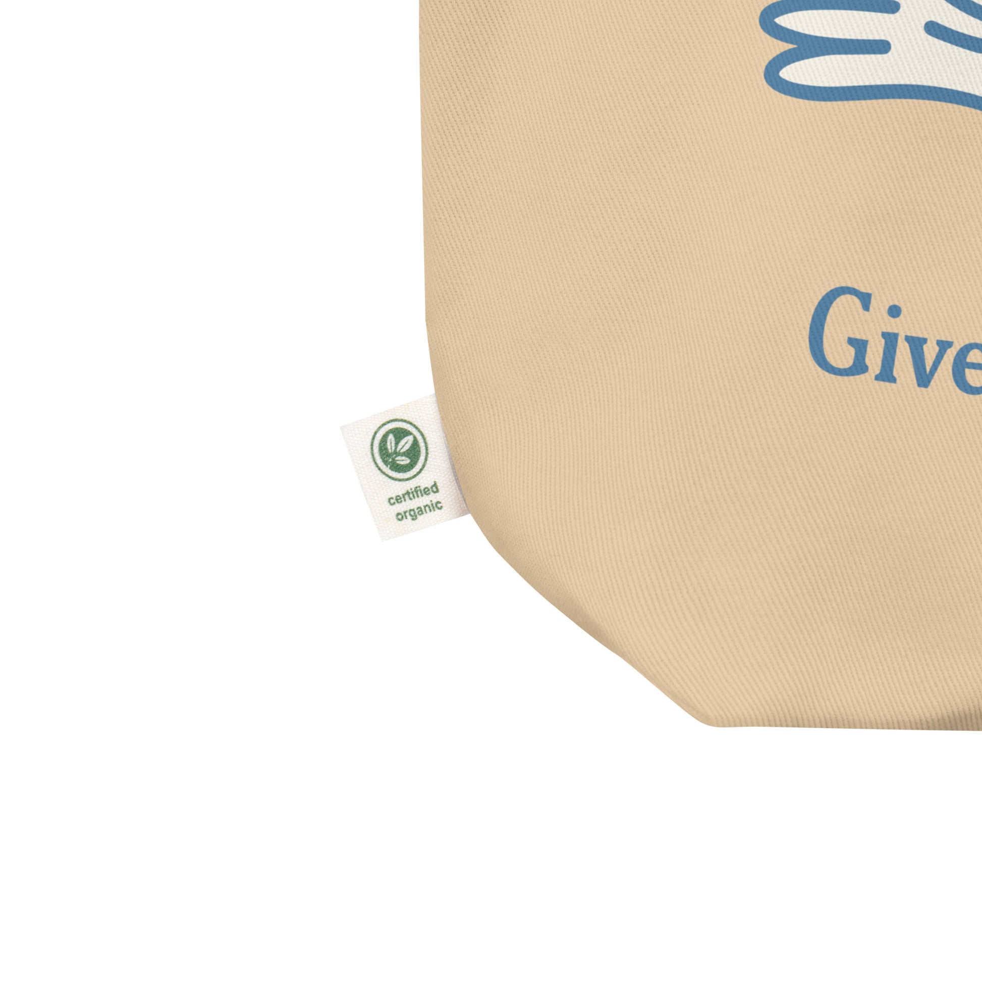 Close-up eco tote corner showing natural canvas texture with partial blue dove illustration and visible “Give Peace a Future” text detail.