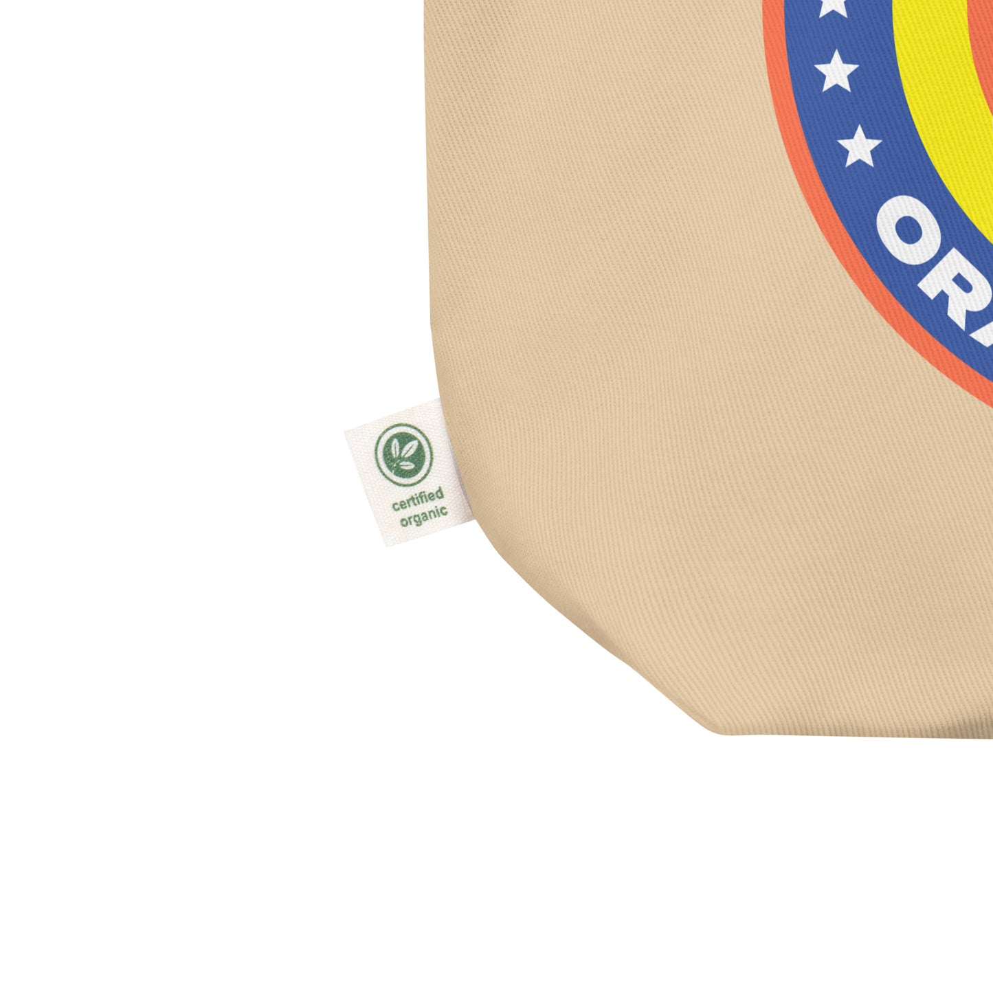 Close-up eco tote corner showing natural canvas texture with partial Birdie Sanders parody detergent badge and visible orange stains slogan detail.