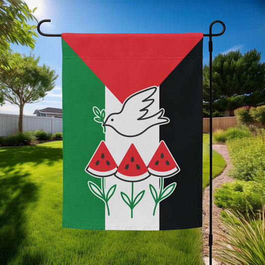 outdoor yard display: Free Palestine garden flag featuring a white dove with olive branch, three watermelon slices, and green stem design on red, white, green, and black flag background.