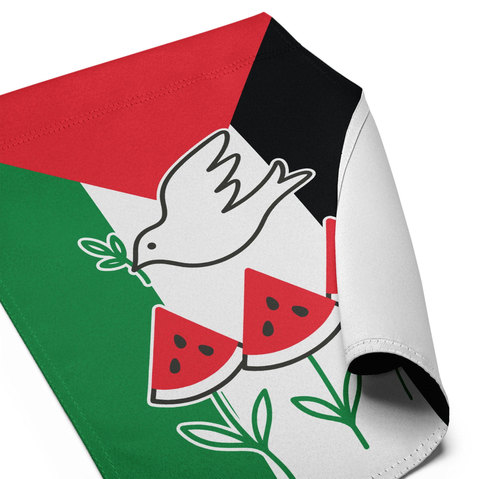 Close-up angled view of the Free Palestine activist garden flag with curled fabric corner, showing dove and watermelon detail, Blue Wave USA activist décor.