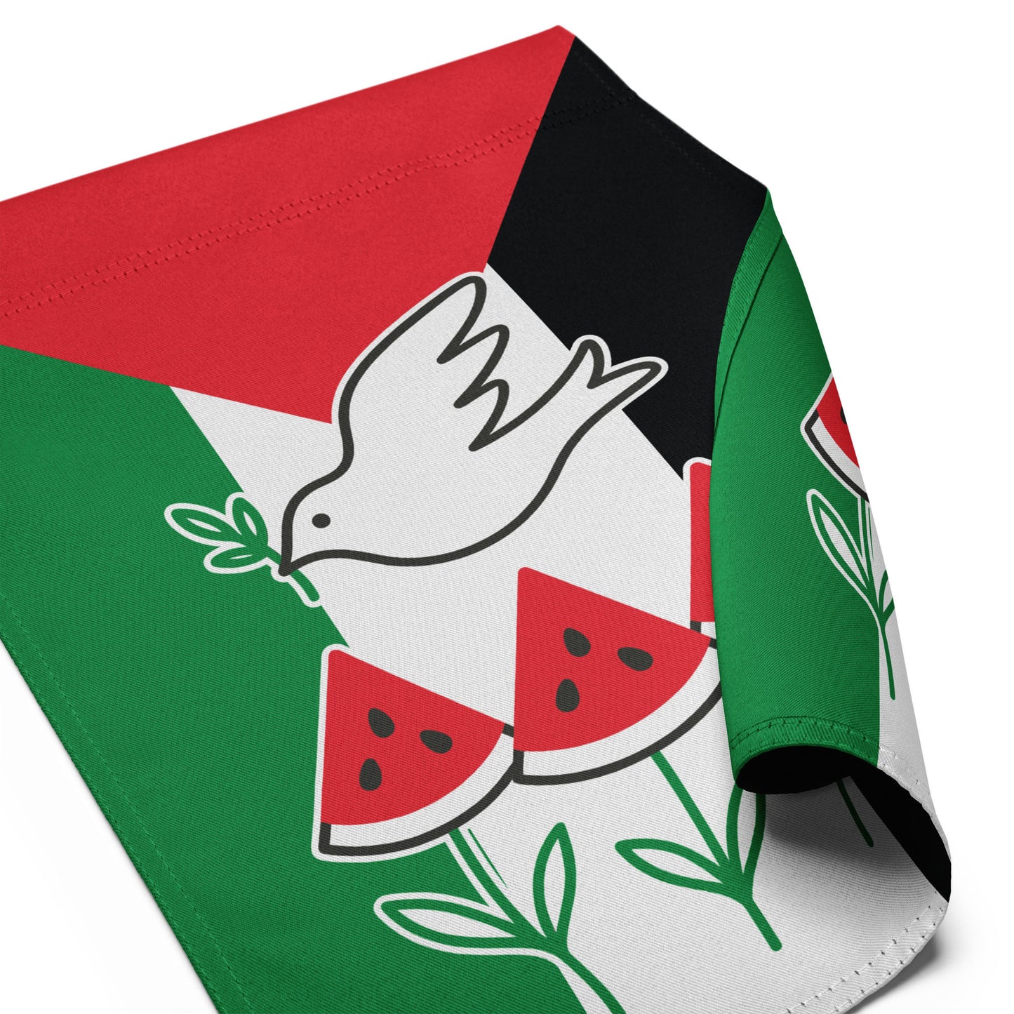 Close-up angled view of the Free Palestine activist garden flag with curled fabric corner, showing dove and watermelon detail, Blue Wave USA activist décor.