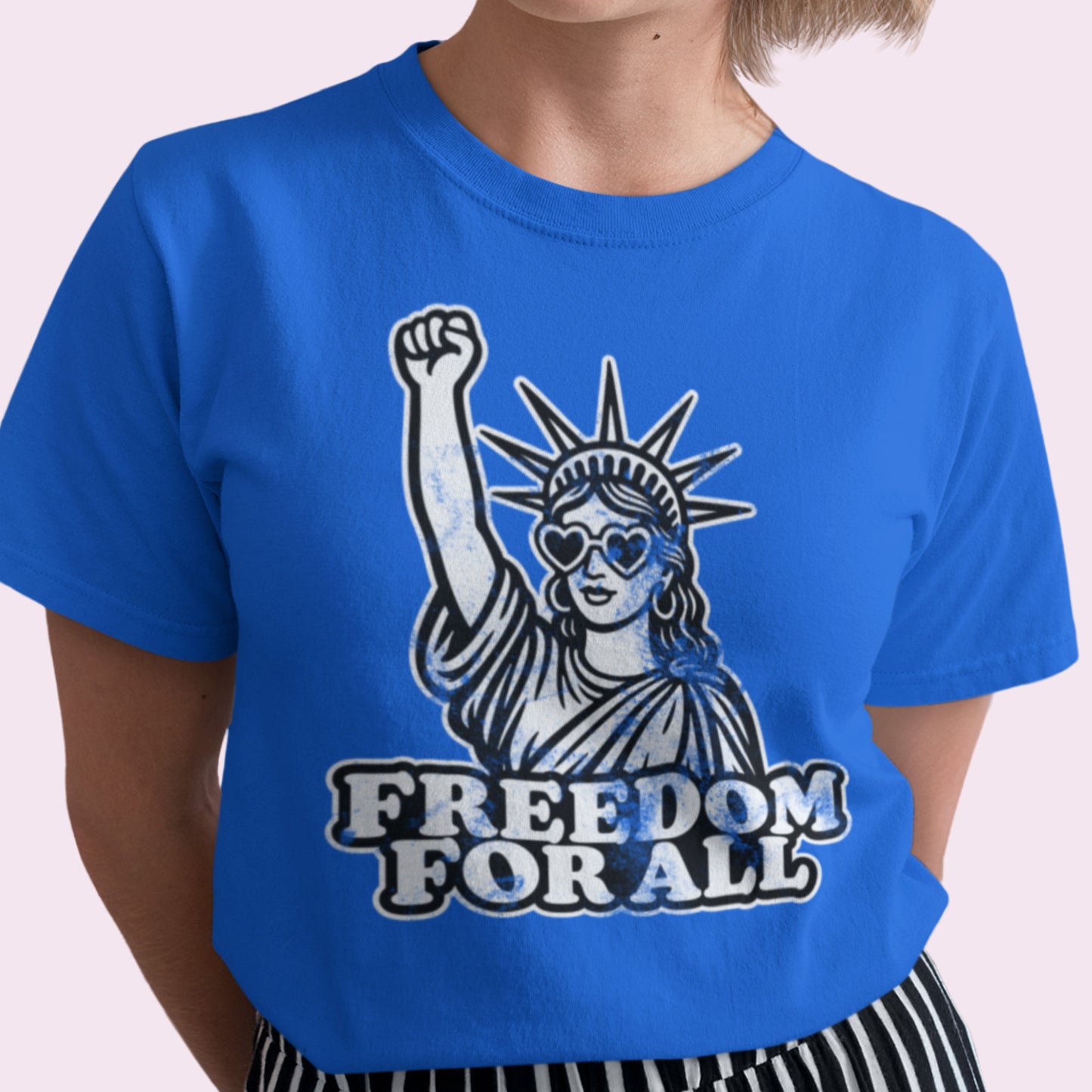 Person in a royal blue Freedom for All tee featuring the illustrated Statue of Liberty graphic. The design captures both strength and hope — a modern symbol of democracy.