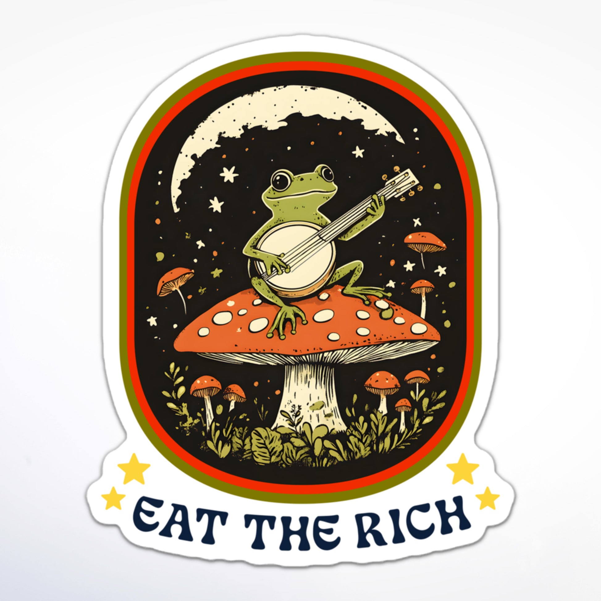 Cottagecore-inspired anti-capitalism sticker with a banjo-playing frog atop a toadstool and protest slogan “Eat The Rich.”