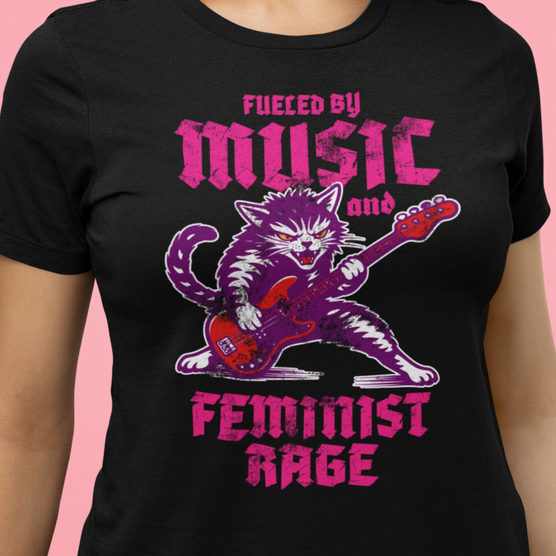 Close-up of a black women’s relaxed t-shirt showing the punk rock cat illustration with electric guitar and gothic text reading “FUELED BY MUSIC AND FEMINIST RAGE,” from Blue Wave USA.