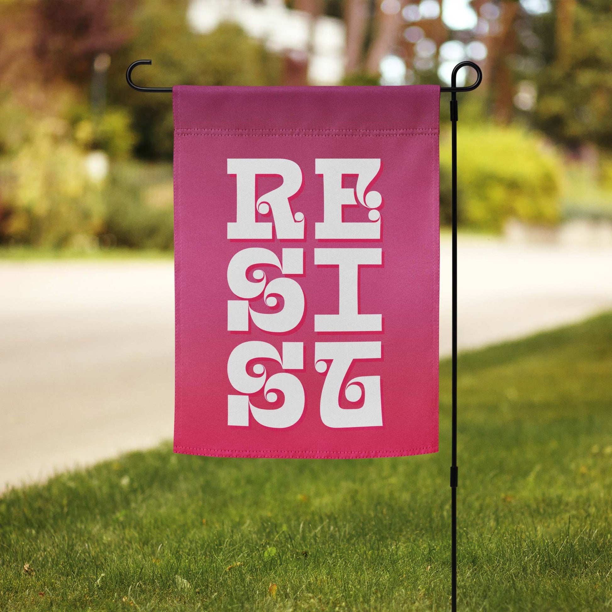 Front View Image: RESIST Garden Flag displayed in a vibrant green garden.