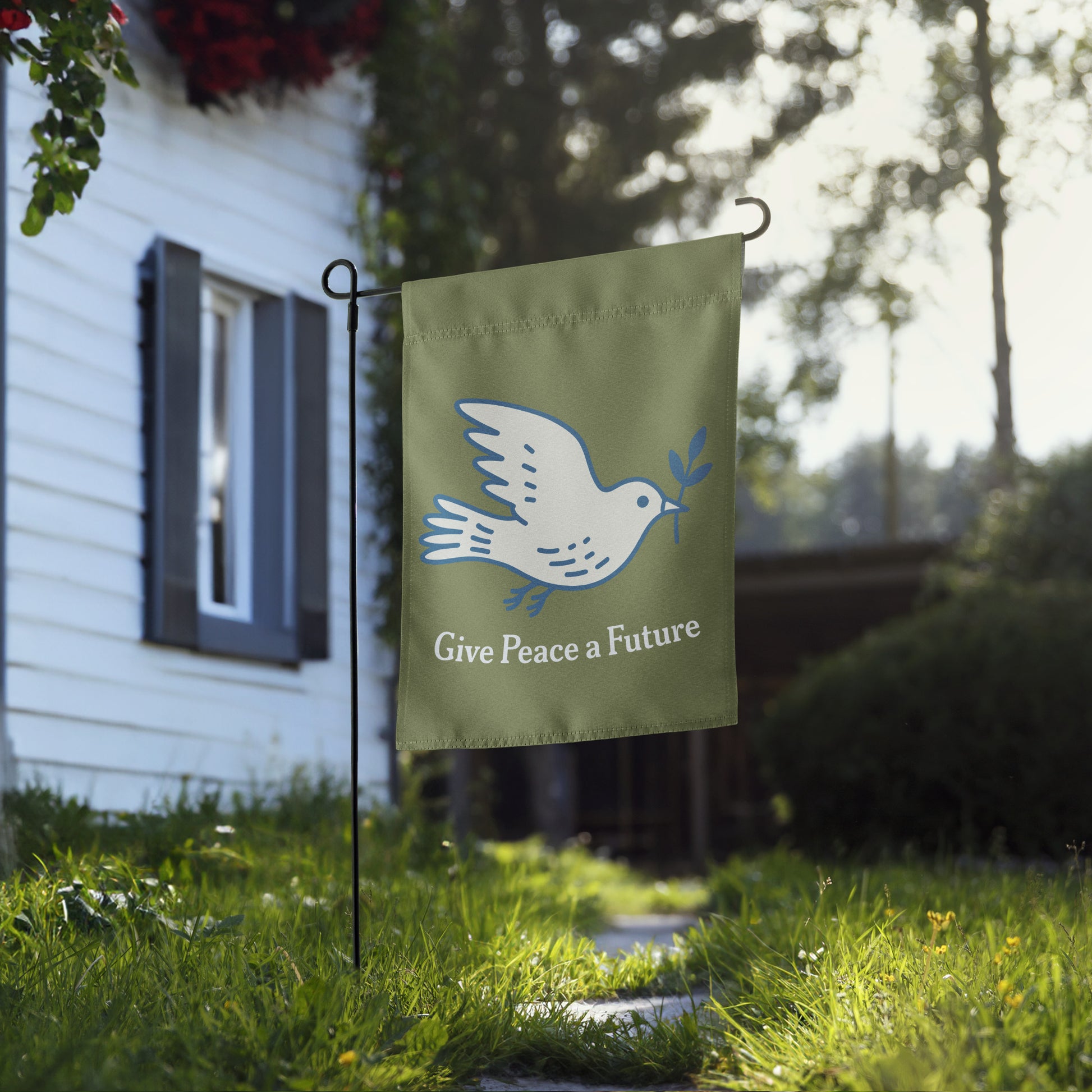 Blue Wave USA garden flag displayed near home walkway, showcasing dove peace artwork and “Give Peace a Future” wording in calm justice-focused yard decor.