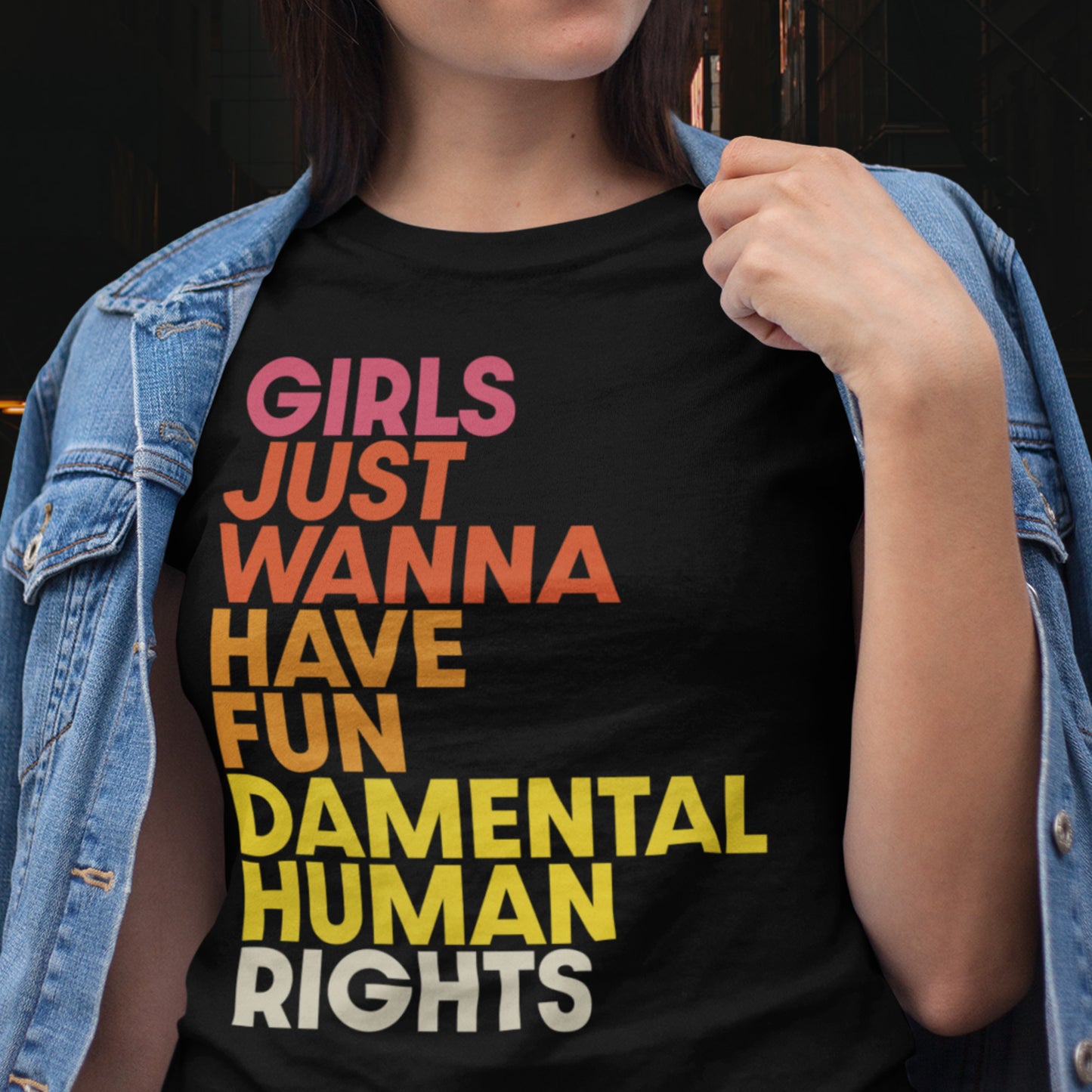 Model wearing black “Girls Just Wanna Have Fundamental Human Rights” feminist t-shirt styled with a denim jacket, Blue Wave USA apparel for equality.
