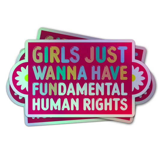 Holographic sticker with colorful text reading “Girls Just Wanna Have Fundamental Human Rights” on a pink background with daisies.