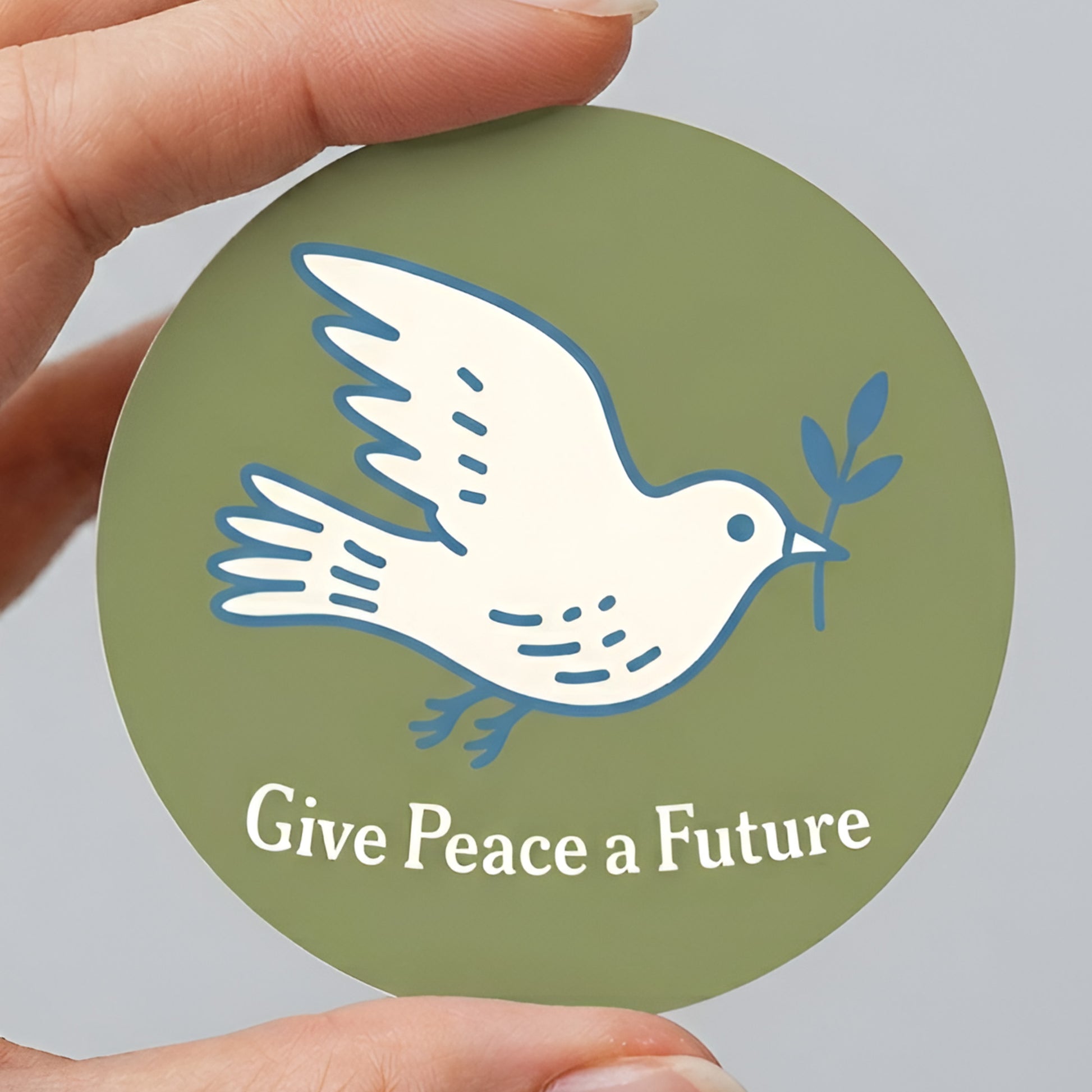 Round sticker featuring a white dove holding an olive branch on olive green background with “Give Peace a Future” text, minimalist anti-war hope design.