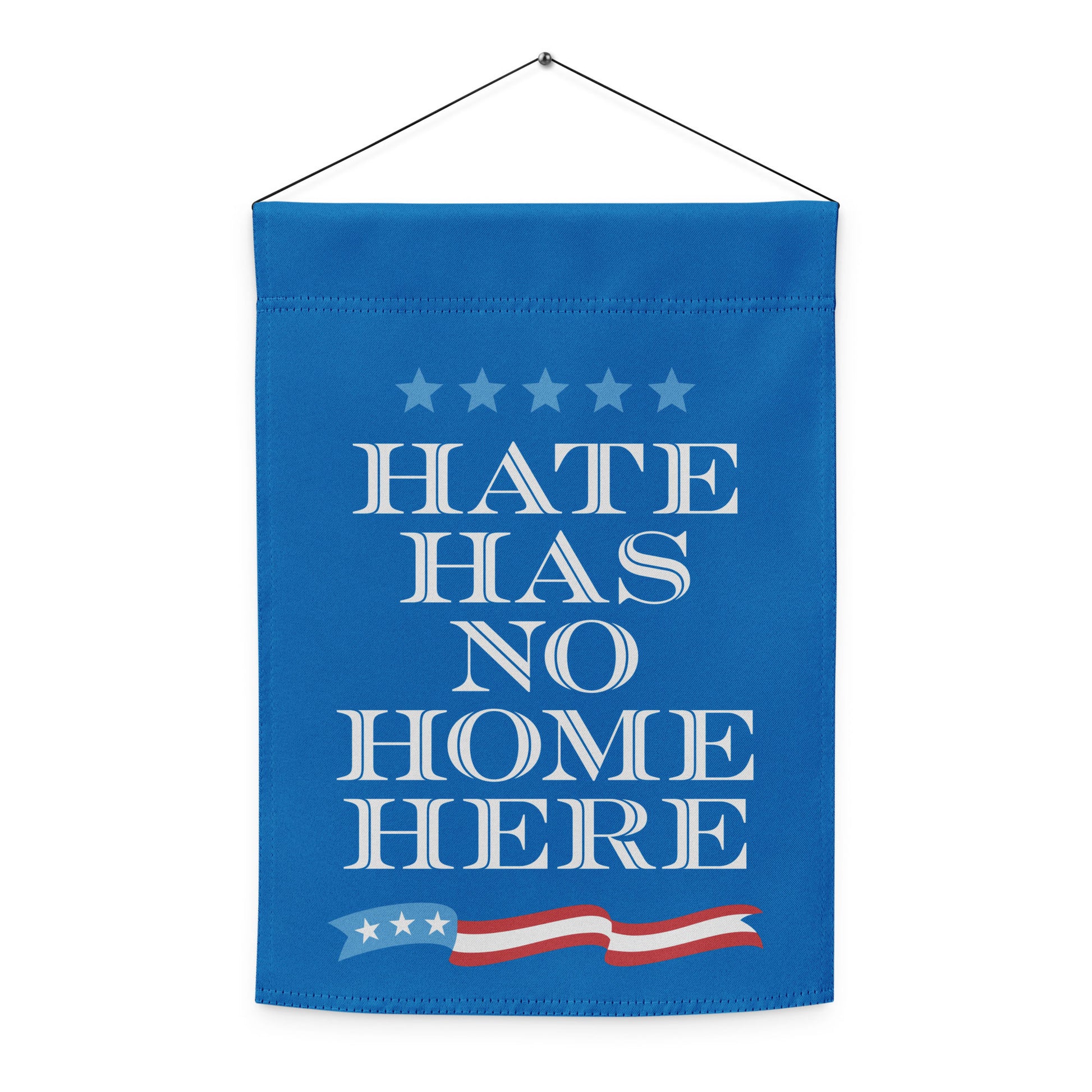 Vertical garden flag shown hanging straight, blue fabric with centered white lettering “HATE HAS NO HOME HERE,” clean patriotic protest design.