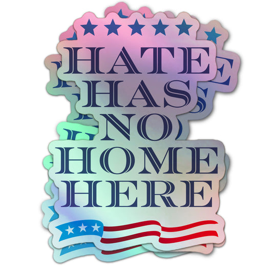 Holographic sticker reading “Hate Has No Home Here” in navy text, with blue stars at the top and a patriotic red and blue banner at the bottom.