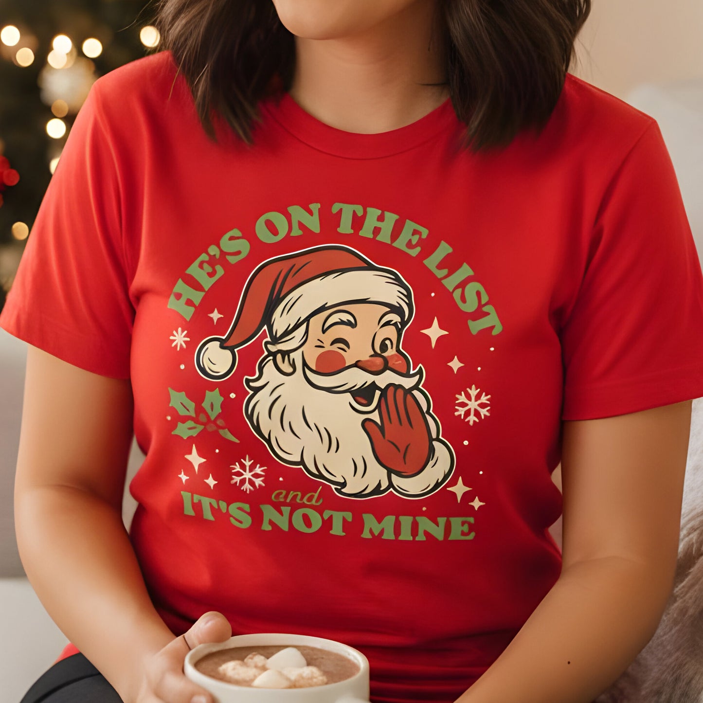 Person wearing a red t-shirt with the cheeky Santa “He’s On the List and It’s Not Mine” graphic, smiling while holding a holiday mug. A playful seasonal favorite from Blue Wave USA.
