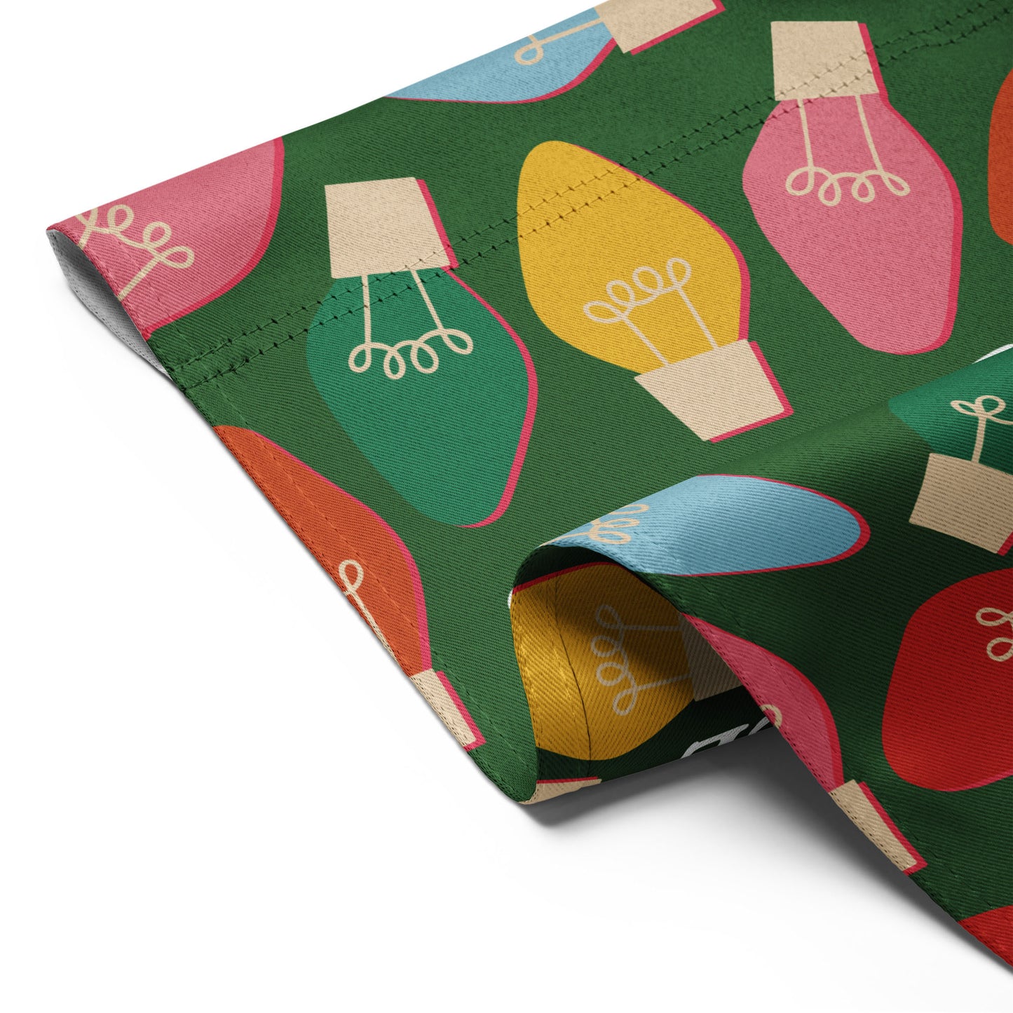 A close-up of the garden flag’s fabric showing colorful illustrated bulbs and part of the message “Holiday Lights Abolish ICE,” emphasizing texture and festive activism artwork.