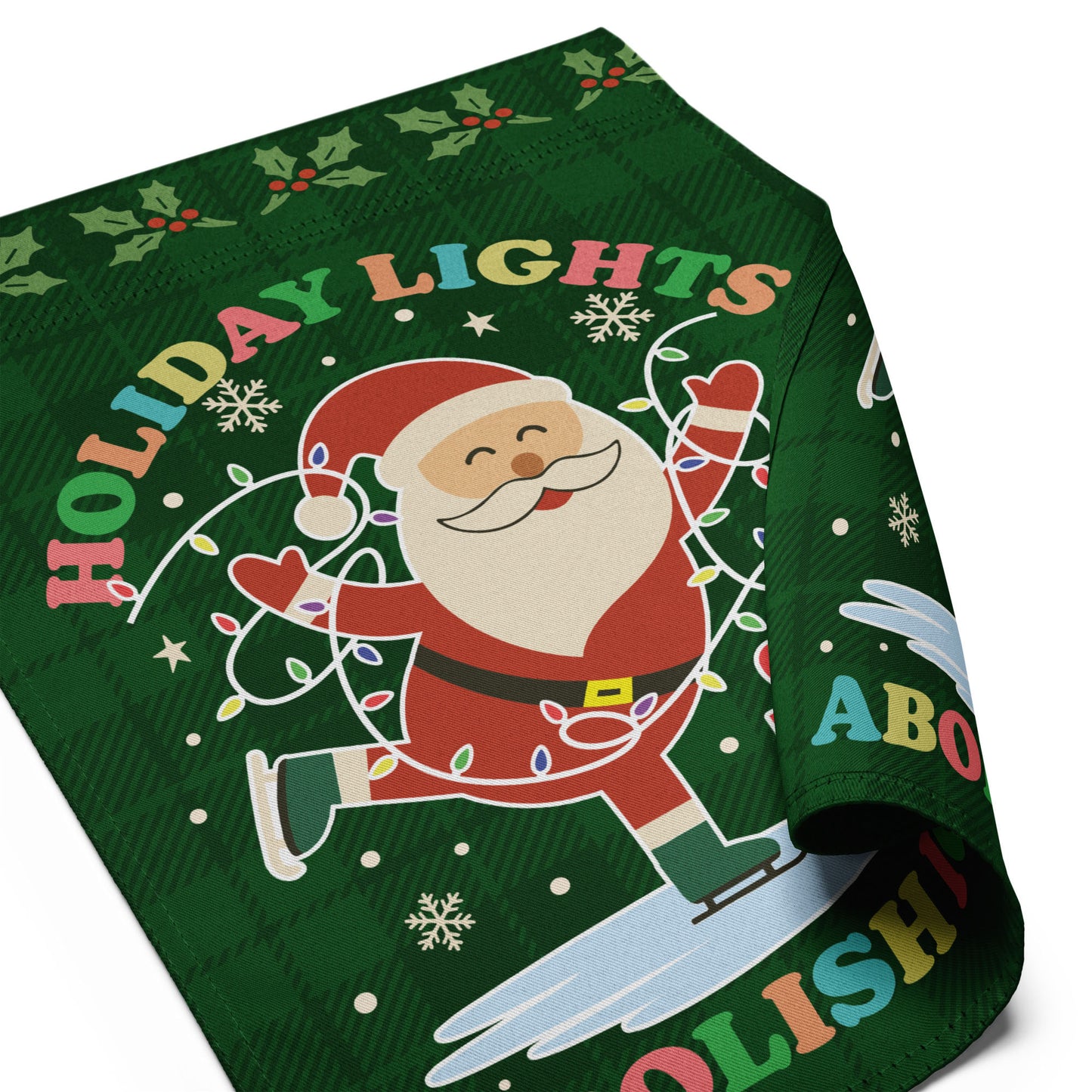 A partially folded green garden flag featuring Santa with bright holiday lights, stars, and gifts surrounding the phrase “HOLIDAY LIGHTS ABOLISH ICE,” emphasizing the vivid festive activist design.