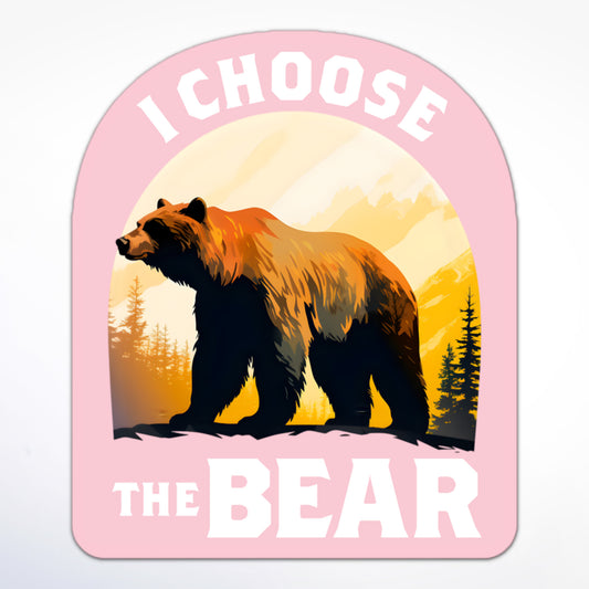 Feminist empowerment sticker with a brown bear in front of pine trees and mountains, reading “I Choose The Bear.”