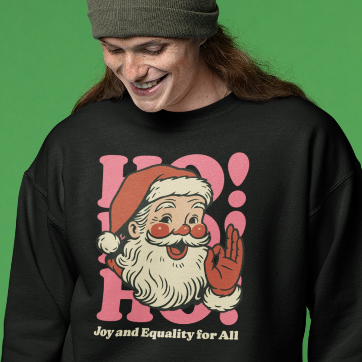 A cozy lifestyle shot of a person wearing the black Santa “Joy and Equality for All” sweatshirt—progressive holiday apparel from Blue Wave USA.