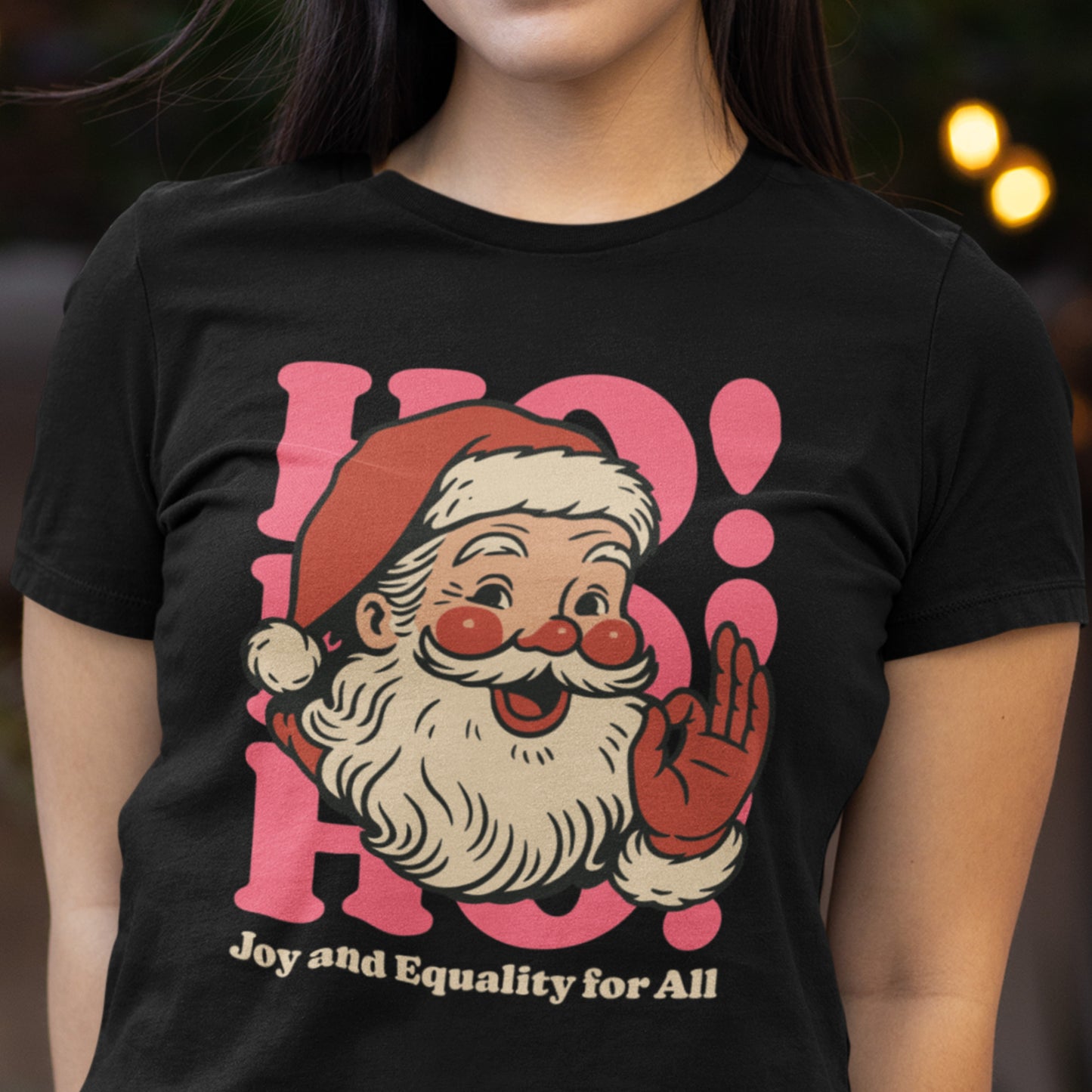 A model wearing the black women’s fitted version of the Santa “Joy and Equality for All” design—progressive holiday apparel from Blue Wave USA.