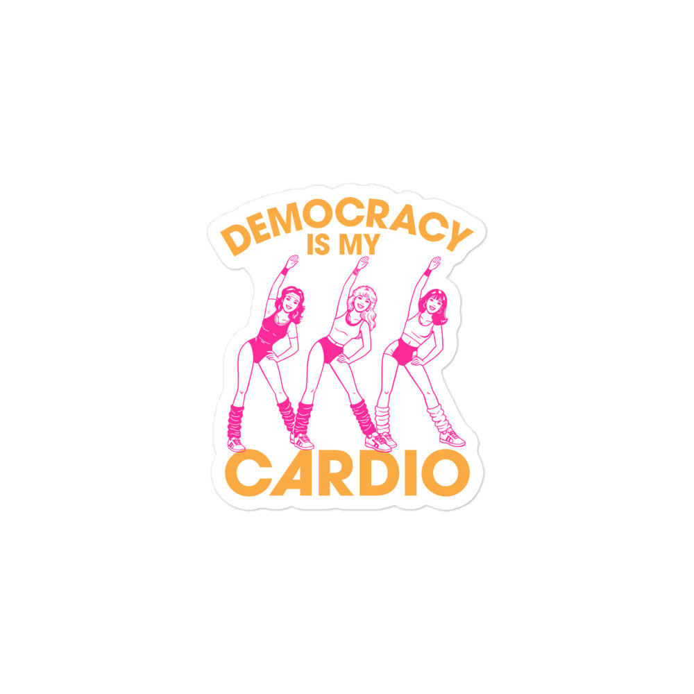 Close-up die-cut political sticker showing vintage aerobics women beneath curved democracy text, blending 80s fitness energy with modern civic humor and progressive apparel aesthetics.