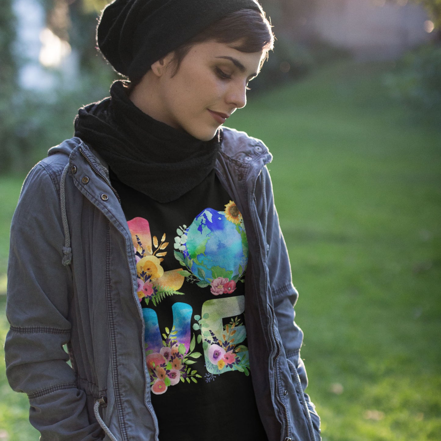 Model wearing “LOVE Earth Floral” t-shirt with globe and flower illustration, progressive activist style.