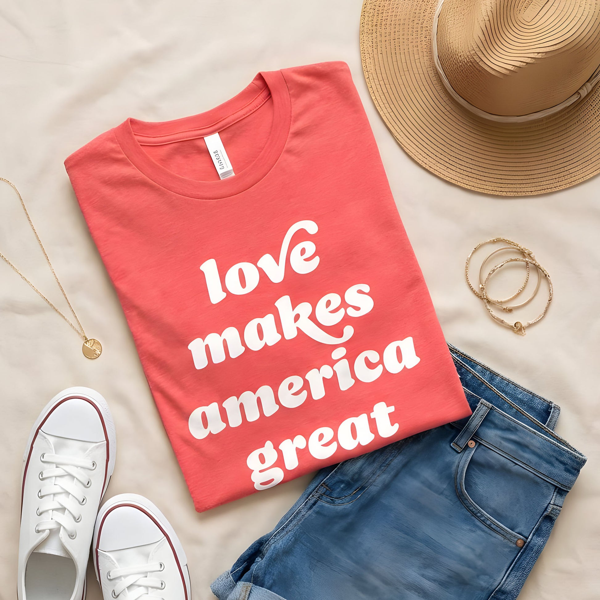 Heather red unisex t-shirt flat lay with vintage-style white lettering reading “Love Makes America Great,” styled with casual accessories for a justice-focused design and progressive Valentine’s Day theme.
