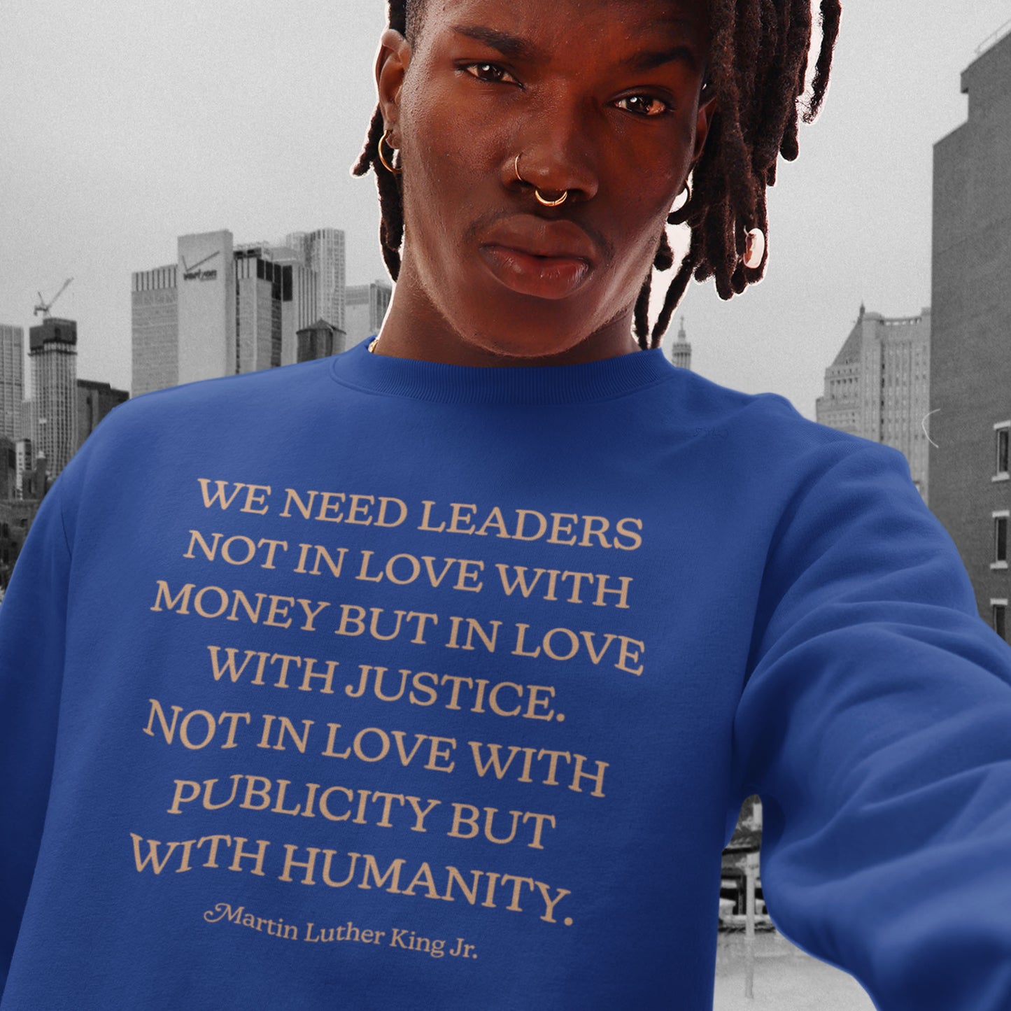 Model wearing a royal blue unisex premium sweatshirt printed with the MLK quote about justice, humanity, and moral leadership. A powerful Blue Wave USA activism design.