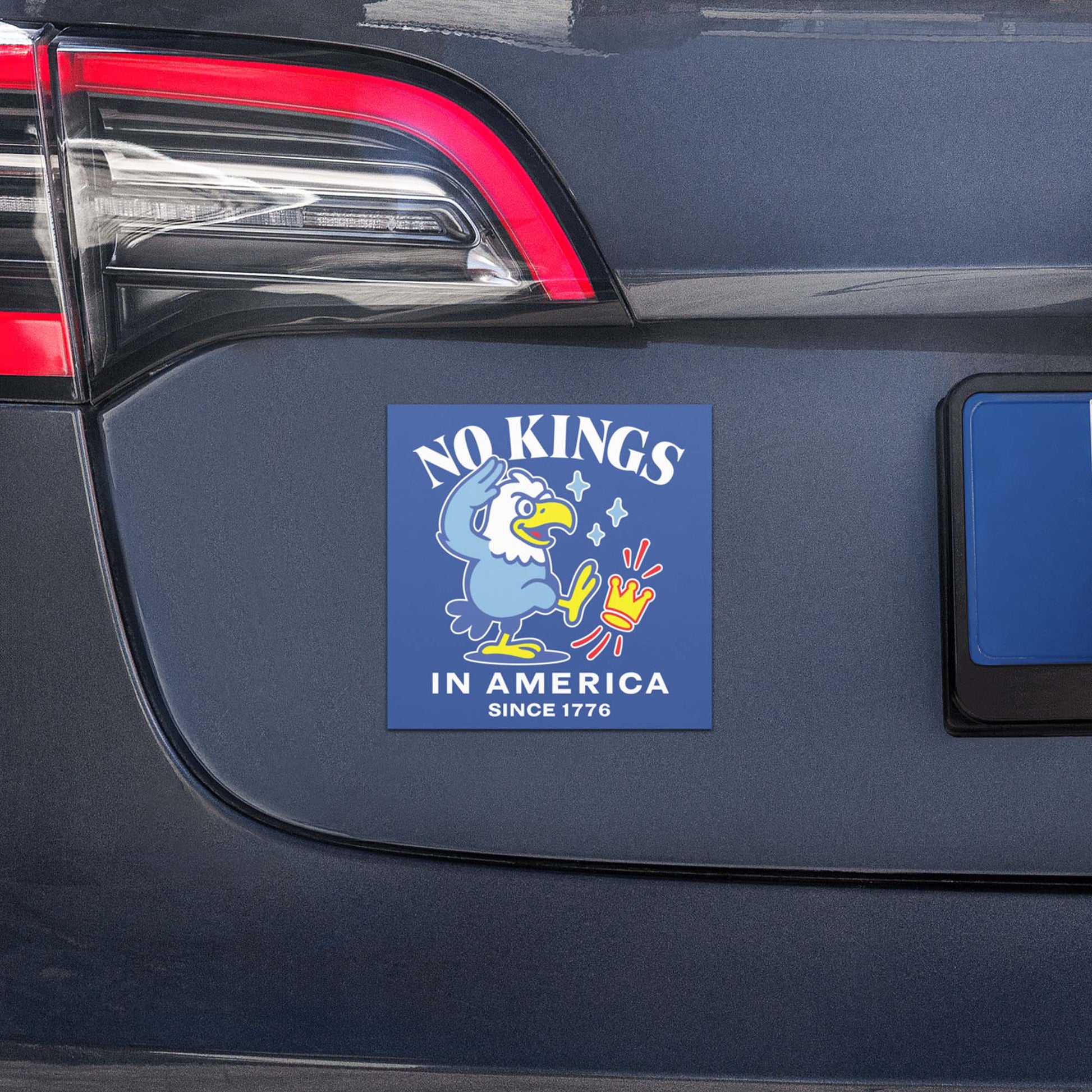 Square car magnet with eagle illustration and “NO KINGS IN AMERICA SINCE 1776” message displayed on vehicle trunk.