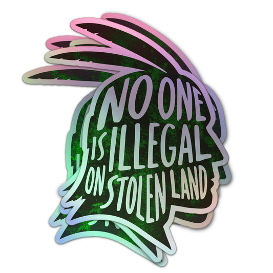 Holographic activist sticker with “No One Is Illegal on Stolen Land” message in hand-lettered text and indigenous profile silhouette.