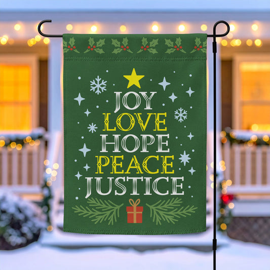 Green garden flag on a metal stand with white and yellow festive lettering reading “JOY LOVE HOPE PEACE JUSTICE,” surrounded by stars, snowflakes, and greenery, outdoor décor by Blue Wave USA.