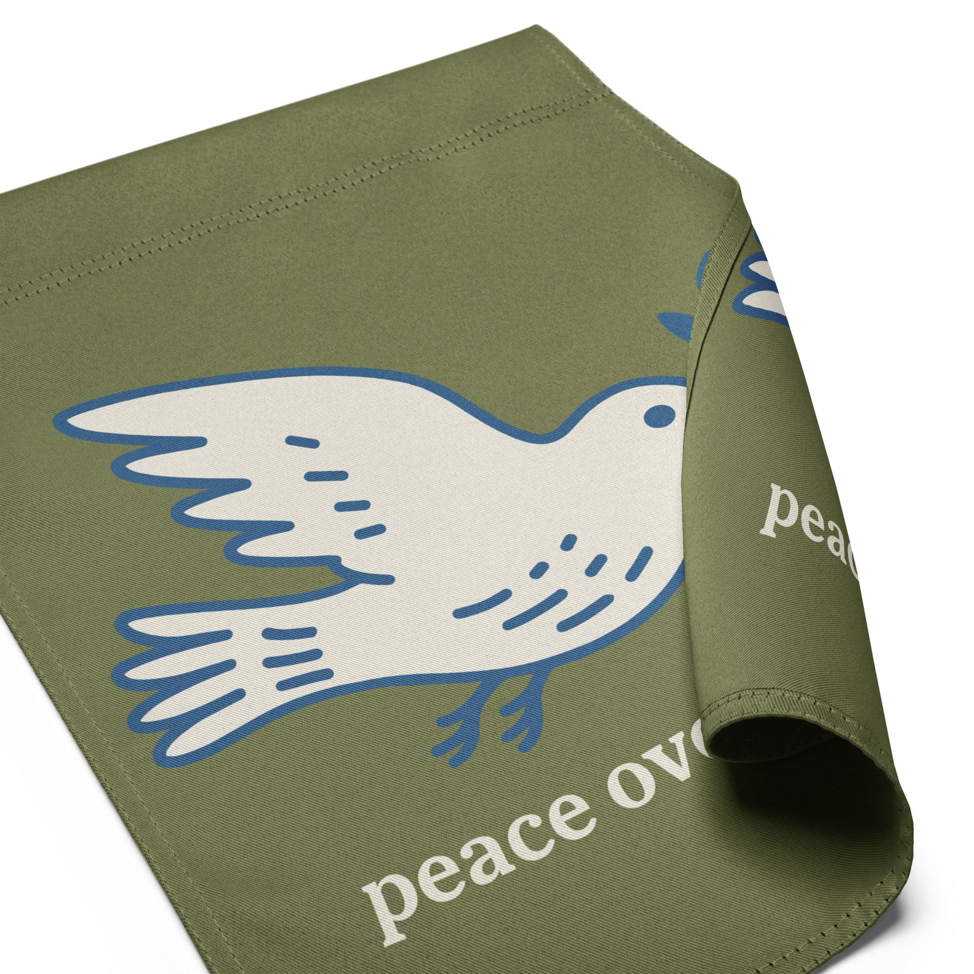 Folded olive green garden flag displaying partial dove peace symbol with visible “peace over war” wording in soft activist outdoor design.