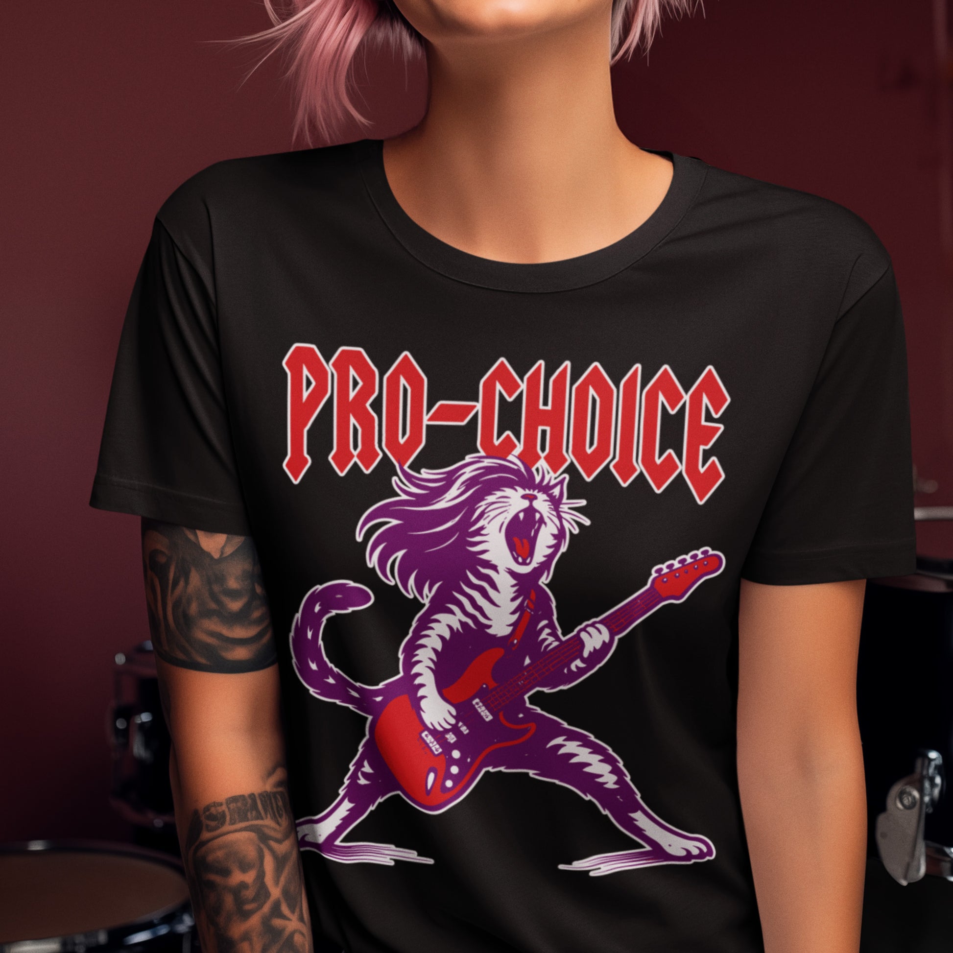Woman wearing black pro-choice graphic t-shirt featuring screaming rockstar cat playing electric guitar with bold “PRO-CHOICE” heavy metal inspired design.