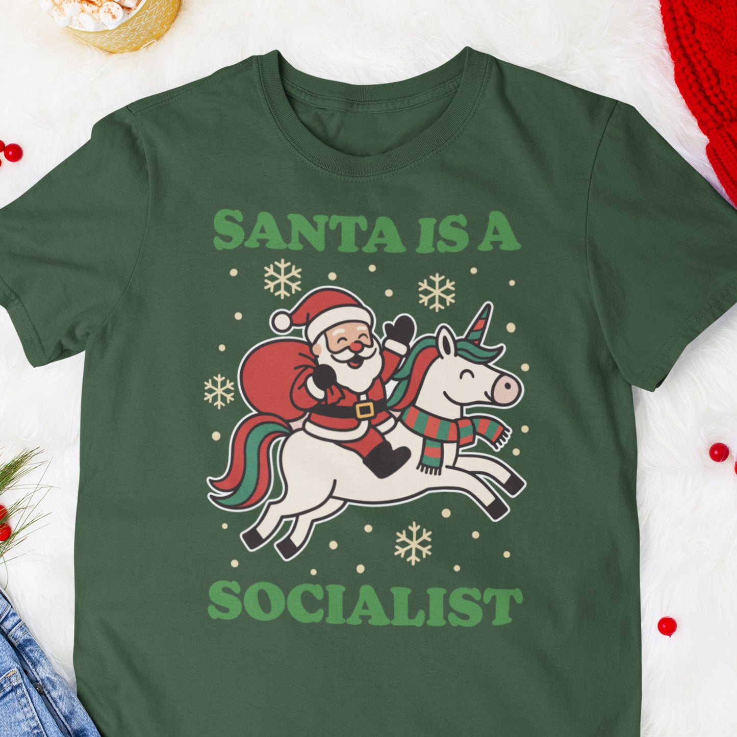 Forest green t-shirt with a retro-style Santa riding a unicorn, white stars, and the printed message “SANTA IS A SOCIALIST” in green.