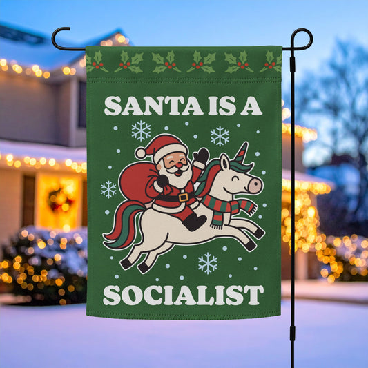 Green garden flag on a metal stand featuring a retro Santa riding a unicorn, snowflakes, and the printed message “SANTA IS A SOCIALIST,” holiday outdoor décor by Blue Wave USA.