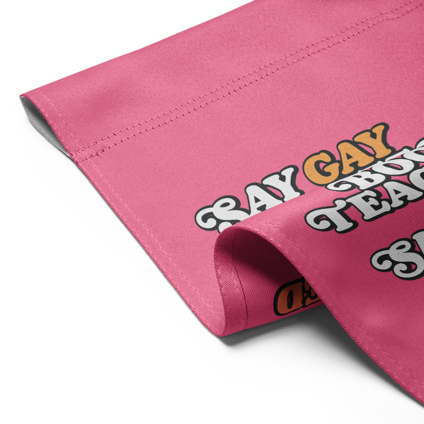 Folded pink garden flag featuring partial retro stacked typography reading “Say Gay Protect Trans Kids Read Banned Books Teach All History Show Love,” progressive yard decor from Blue Wave USA.