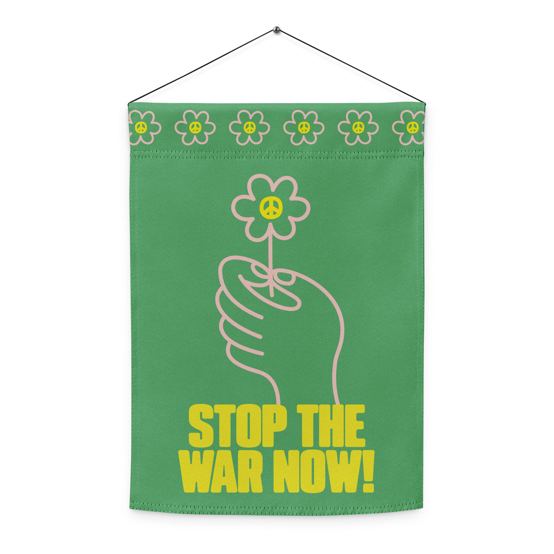 Vertical garden flag with top sleeve and hanging rod featuring flower-in-hand illustration and bold “STOP THE WAR NOW!” protest message.
