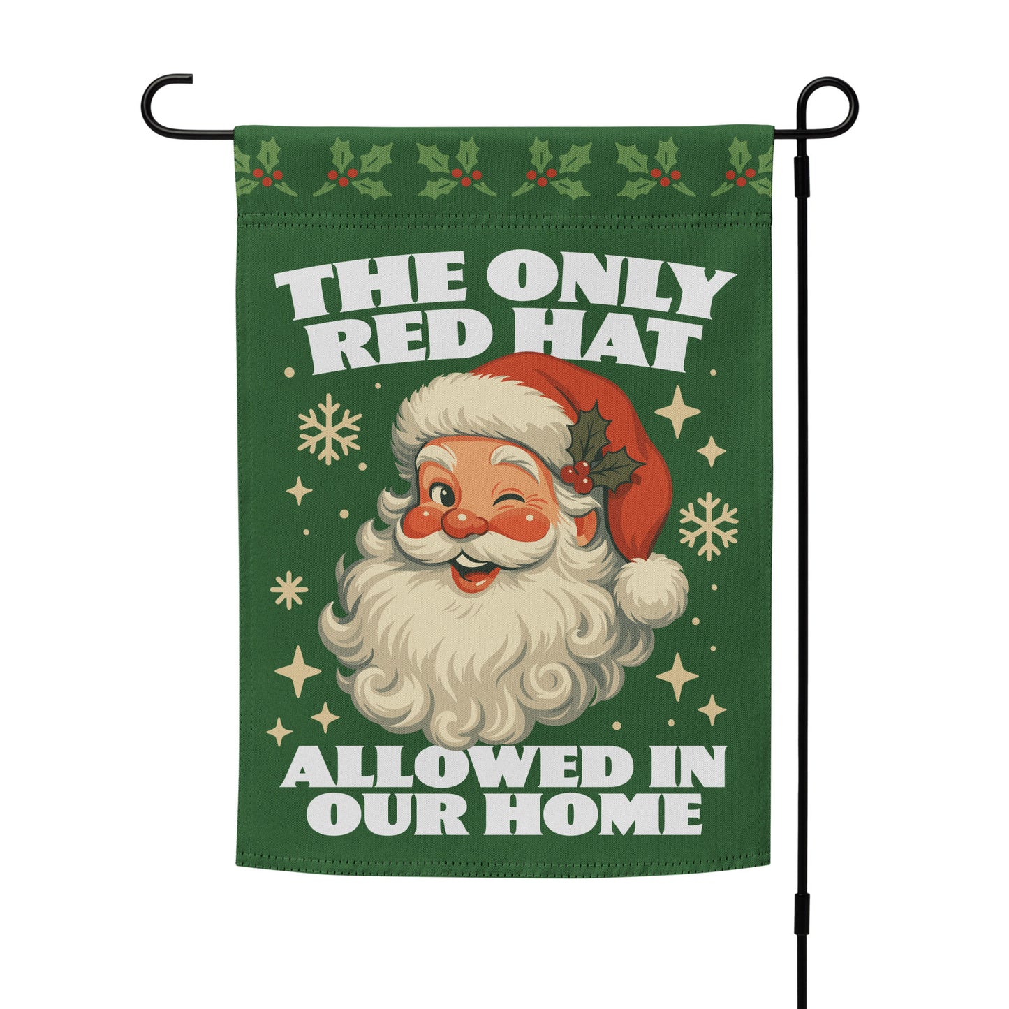 Green garden flag on a metal stand showing a retro Santa illustration with festive motifs and the printed phrase “THE ONLY RED HAT ALLOWED IN OUR HOME.”