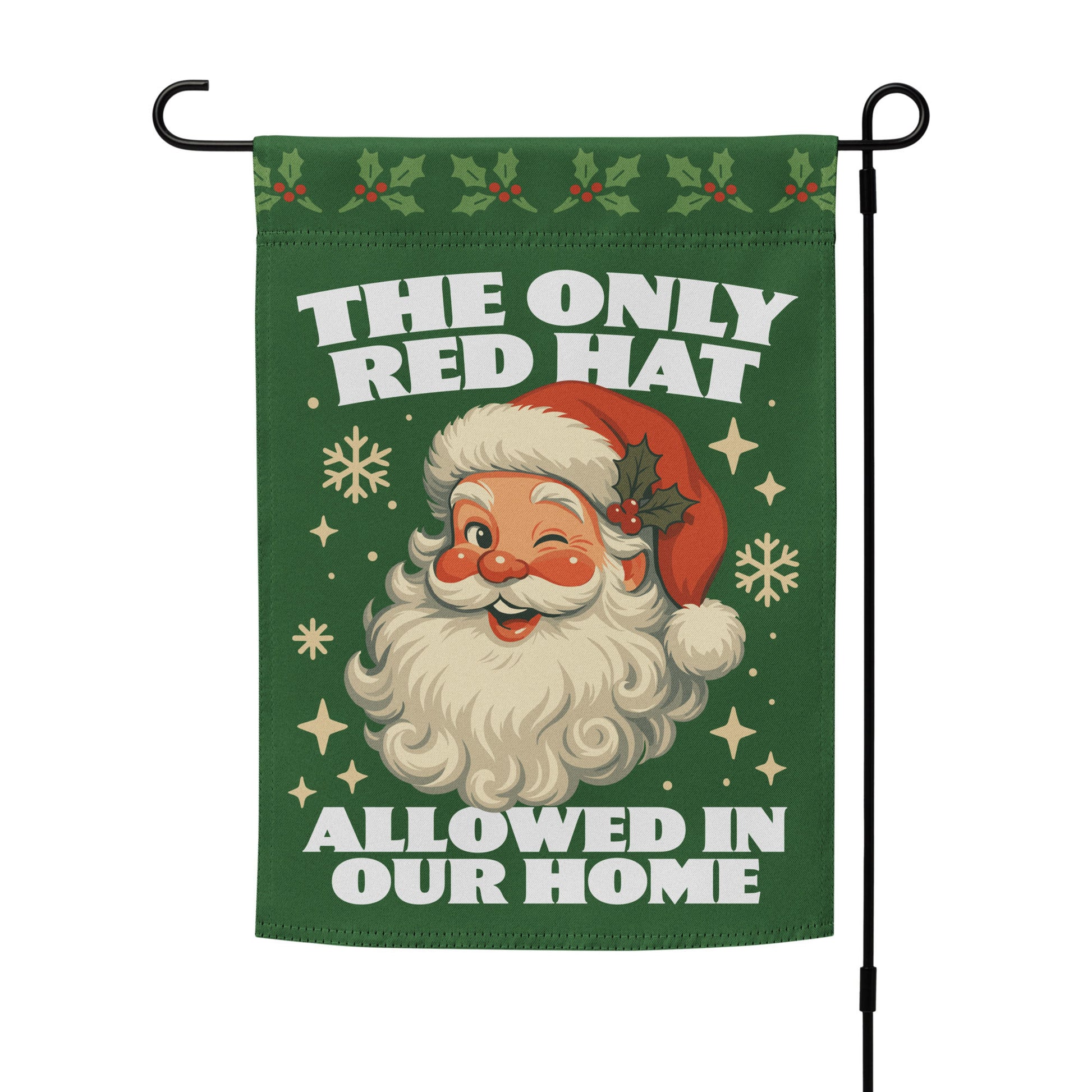 Green garden flag on a metal stand showing a retro Santa illustration with festive motifs and the printed phrase “THE ONLY RED HAT ALLOWED IN OUR HOME.”