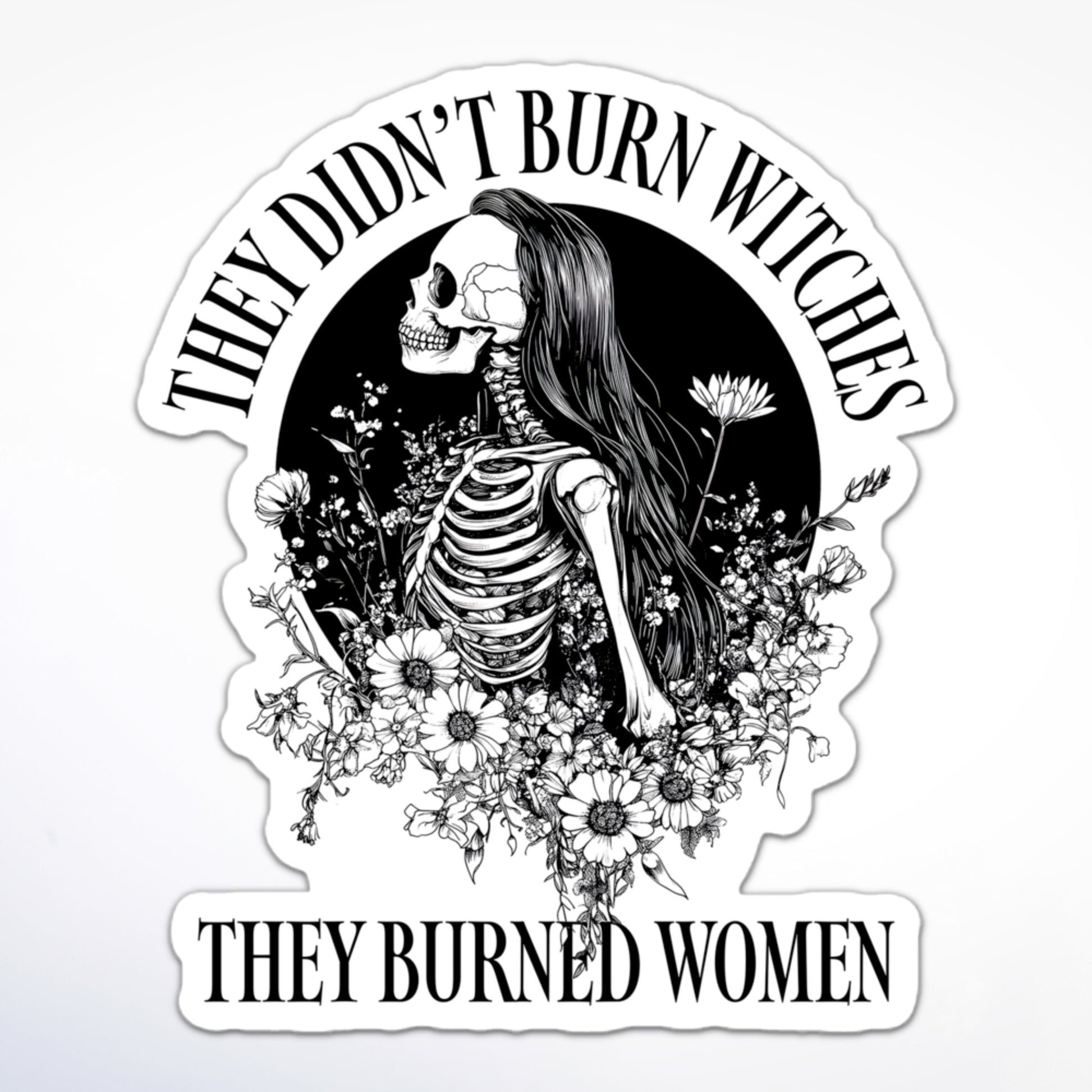 Feminist sticker featuring a female skeleton with long hair and flowers, encircled by the phrase “They Didn’t Burn Witches, They Burned Women.”