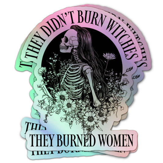 Feminist holographic sticker featuring a female skeleton with long hair and flowers, encircled by the phrase “They Didn’t Burn Witches, They Burned Women.”