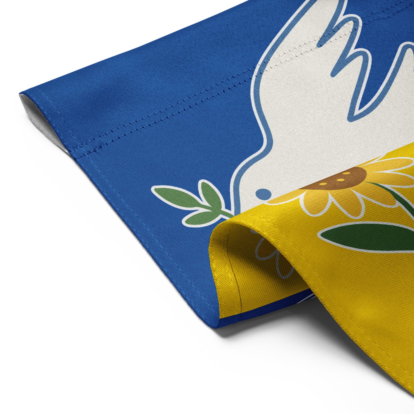 Close-up of the Ukraine Solidarity progressive garden flag with curled edge showing dove and sunflower detail, Blue Wave USA activist décor.