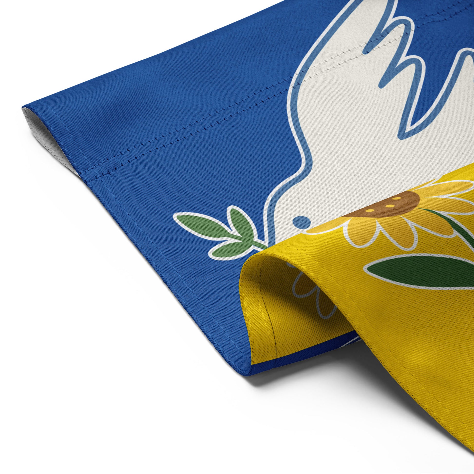 Close-up of the Ukraine Solidarity progressive garden flag with curled edge showing dove and sunflower detail, Blue Wave USA activist décor.