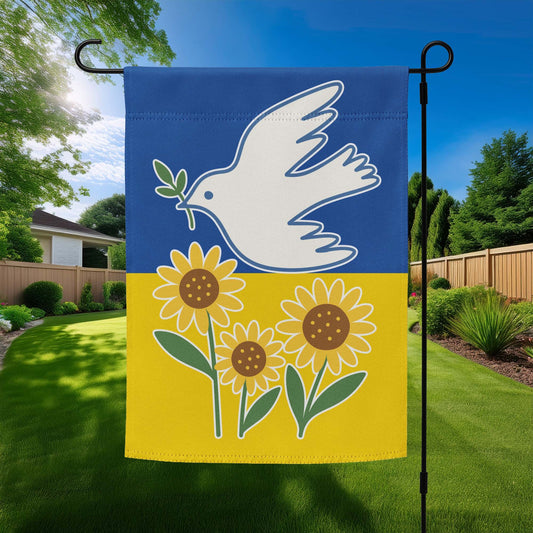 Ukraine Solidarity garden flag featuring white dove with olive branch and sunflowers on a blue and yellow background, displayed outdoors on a flag stand.